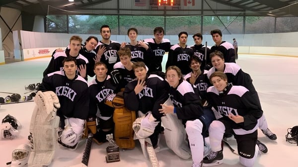 Eine Gruppe Schüler der The Kiski School posiert in Hockeyuniformen auf der Eislaufbahn.