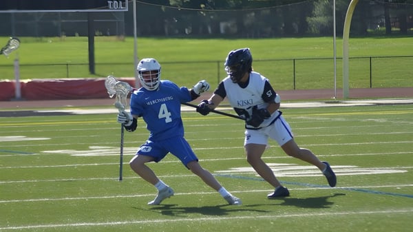 Zwei Spielerinnen im Lacrosse-Uniform treten auf dem Spielfeld der The Kiski School gegeneinander an.
