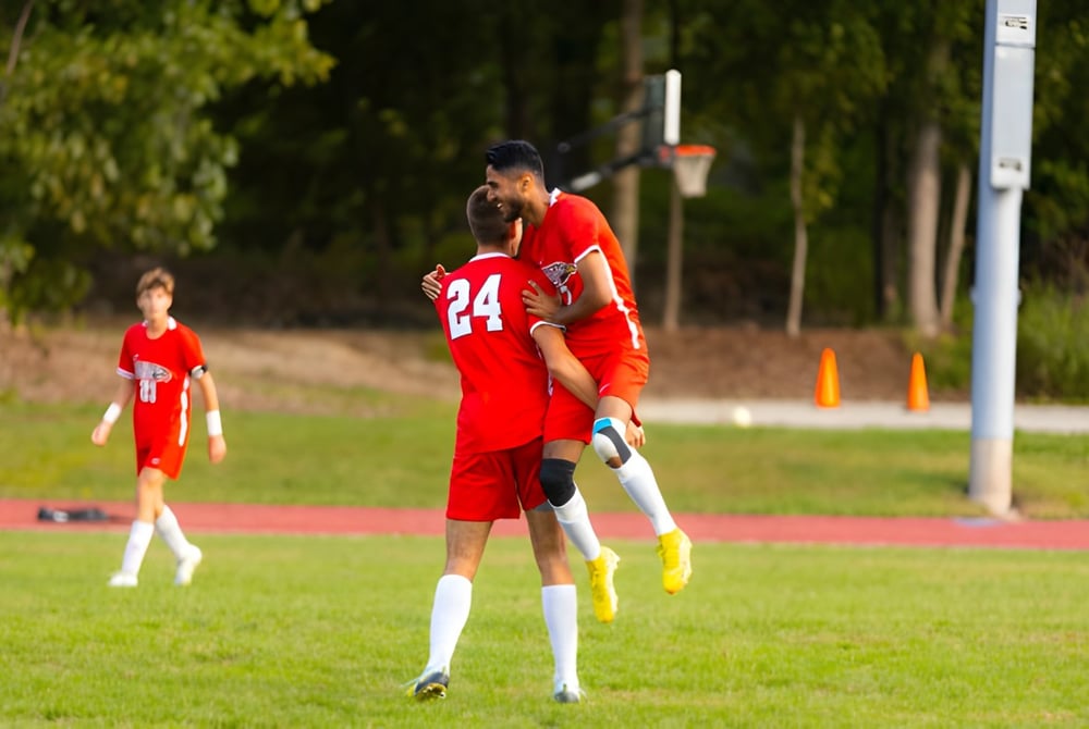 Zwei Fußballspieler in roten Trikots spielen auf dem Sportplatz der The Knox School.