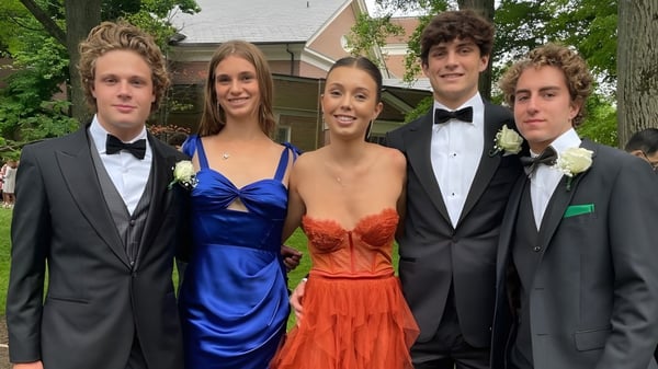 Eine Gruppe von fünf Jugendlichen in formeller Kleidung steht vor einem Wohngebäude auf dem Campus der The Lawrenceville School.