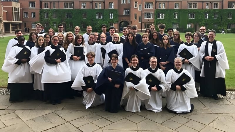 Eine Gruppe von Schülerinnen und Schülern der The Leys School steht in akademischen Gewändern vor einem historischen Gebäude.