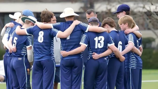 Eine Gruppe von Schülern der The Leys School steht auf dem Sportplatz und umarmt sich gegenseitig zur Unterstützung.