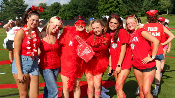 Eine Gruppe junger Frauen posiert auf einer Wiese auf dem Campus der The Madeira School.