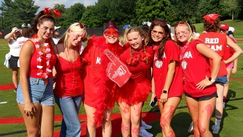 Eine Gruppe junger Frauen posiert auf einer Wiese auf dem Campus der The Madeira School.