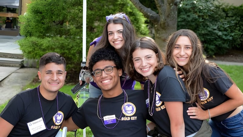 Eine Gruppe von Schülerinnen und Schülern der The Masters School posiert gemeinsam im grünen Außenbereich.