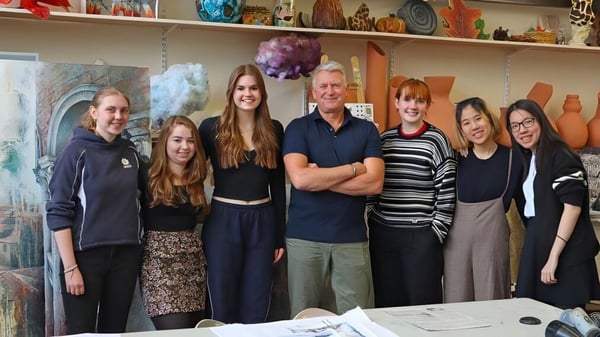 Eine Gruppe von Schülerinnen und Schülern mit Erwachsenen im kunstvoll gestalteten Raum der The Mount School York.