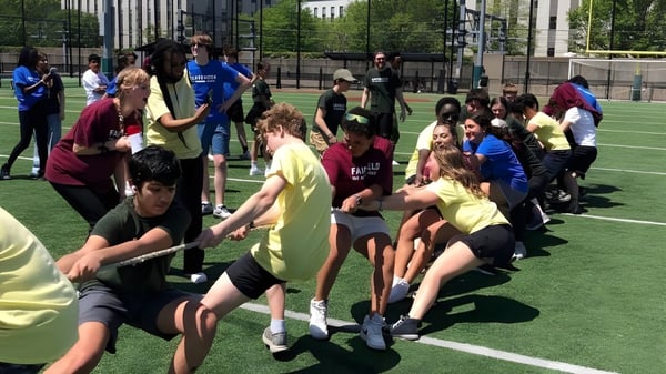 Eine Gruppe von Schülerinnen und Schülern der The Newman School nimmt an einer Sportaktivität auf dem Sportfeld teil.