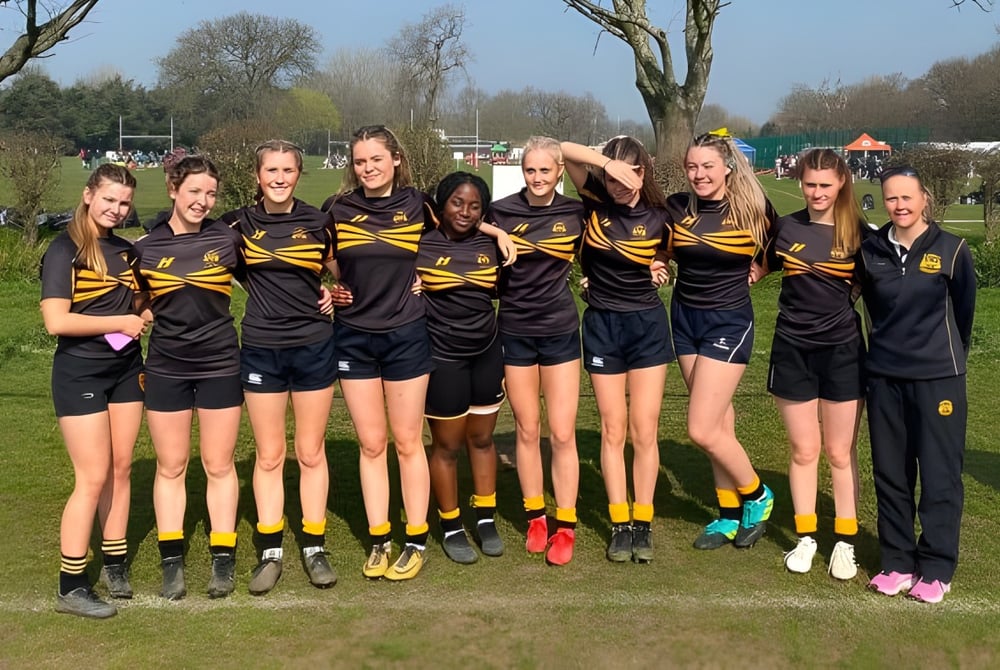 Eine Gruppe junger Sportlerinnen steht auf einem Feld auf dem Campus der The Oratory School.