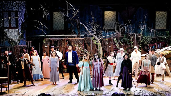 Eine Gruppe von Schülern der The Peddie School trägt auf einer Veranstaltung elegante Kostüme vor einem dekorierten Hintergrund.