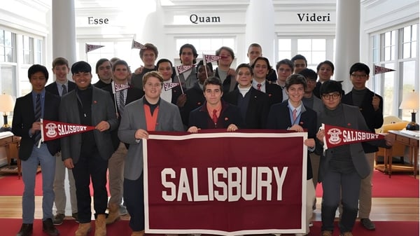 Eine Gruppe Schülerinnen und Schüler hält auf dem Campus der The Salisbury School ein großes Banner mit dem Schriftzug SALISBURY.