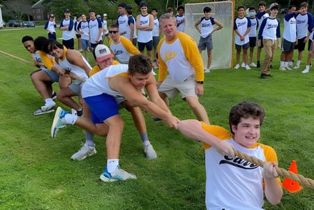 Schüler der The Salisbury School nehmen an einer Team-Building-Aktivität auf einer Wiese teil.