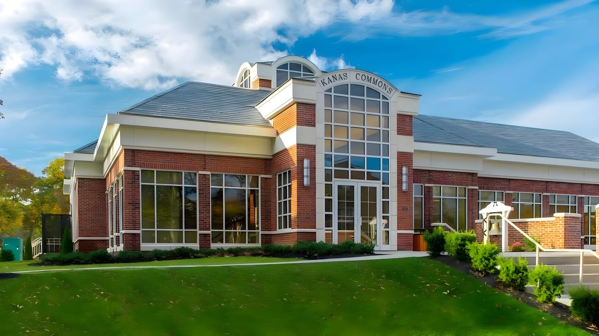 Das moderne mehrstöckige Gebäude der The Stony Brook School mit verglaster Eingangszone und gepflegtem Rasen.