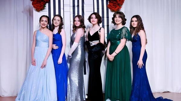 Eine Gruppe von sechs jungen Frauen in eleganten Abendkleidern bei einer Abendveranstaltung auf dem Campus der The Webb School.