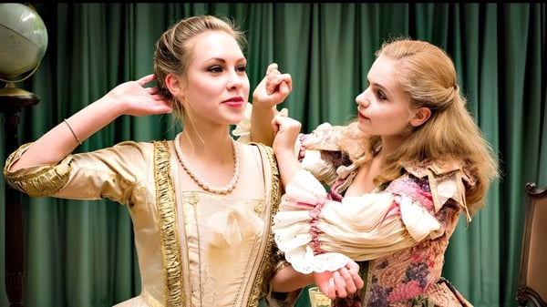Zwei Frauen in historischen Kostümen führen vor einem grünen Vorhang eine Theateraufführung auf dem Campus der The Yehudi Menuhin School auf.