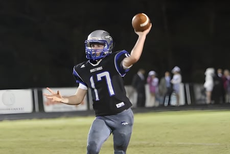 Ein Football-Spieler der The Beekman School steht auf dem Spielfeld und bereitet sich auf den Wurf vor.