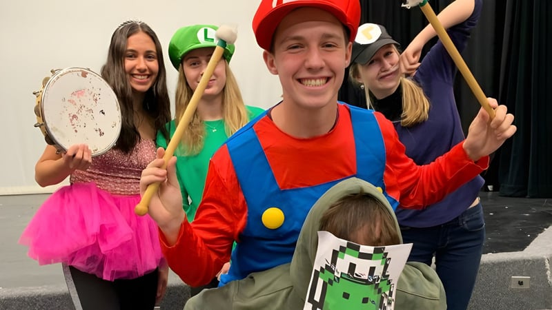 Eine Gruppe von Schülern der Thomas A. Blakelock High School in bunten Kostümen bei einer spielerischen Aufführung.