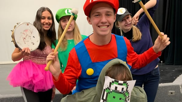 Eine Gruppe von Schülern der Thomas A. Blakelock High School in bunten Kostümen bei einer spielerischen Aufführung.