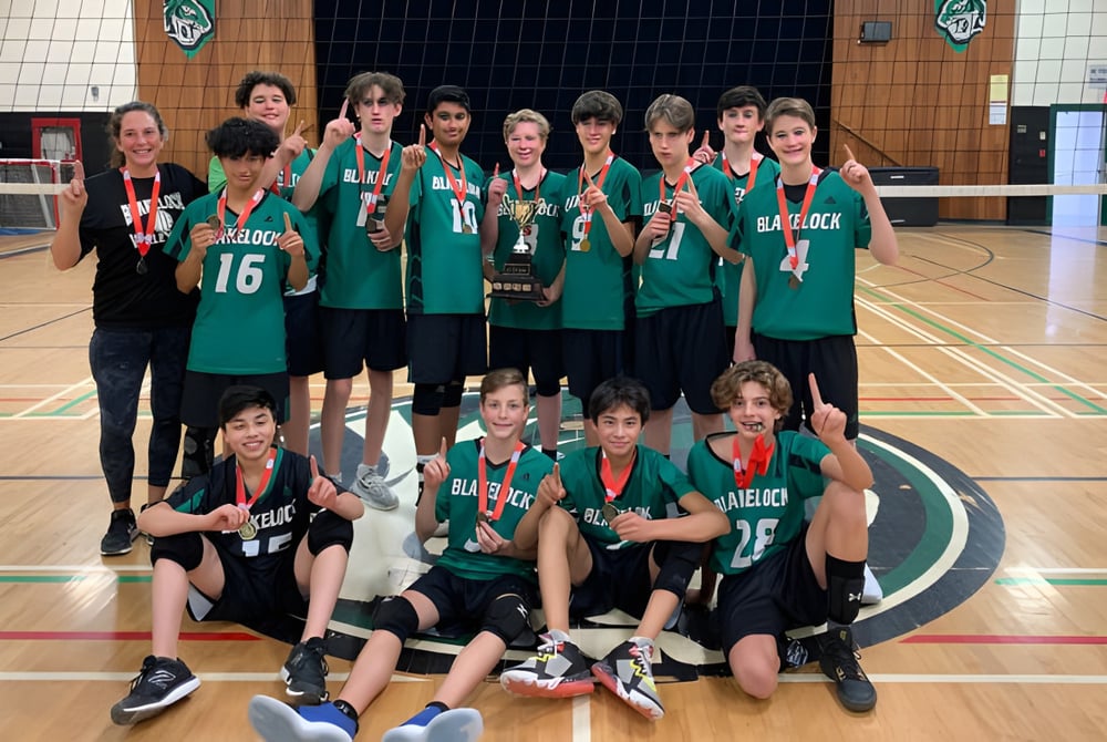 Eine Gruppe junger Sportlerinnen in grünen Trikots auf dem Basketballfeld der Thomas A. Blakelock High School.