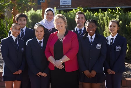 Eine Gruppe von Schülerinnen und Schülern steht vor einem Backsteingebäude auf dem Campus der Thornlie Senior High School.
