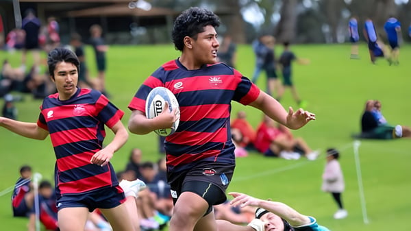 Zwei Rugbyspieler in gestreiftem Trikot laufen auf dem Spielfeld der Thornlie Senior High School.