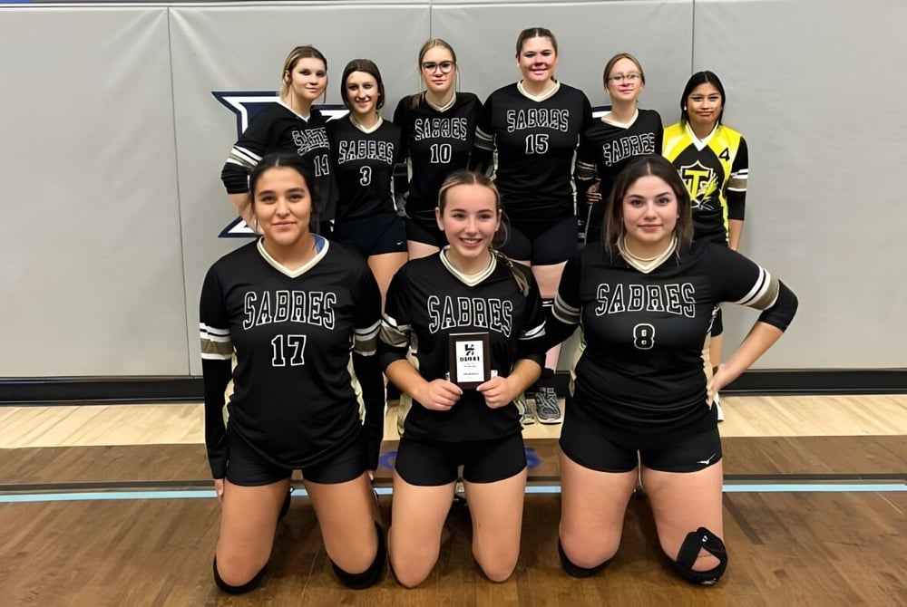 Eine Gruppe junger Schülerinnen in Sportuniformen posiert zusammen in der Turnhalle der Thorsby Junior Senior High School.