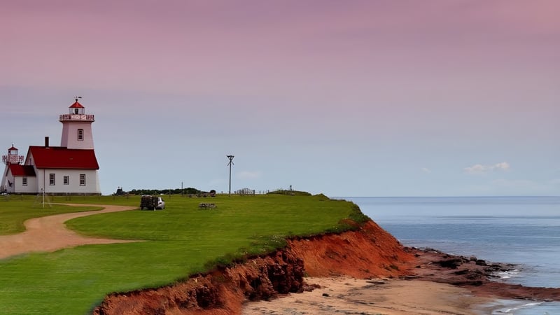 Ein Leuchtturm steht auf einem grasbewachsenen Hügel mit Blick auf die Felsküste und das Meer auf dem Gelände der Three Oaks Senior High.