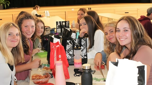 Schülerinnen der Three Oaks Senior High sitzen an einem Tisch und beschäftigen sich mit Make-up und Beautysachen.