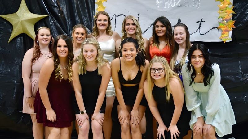 Eine Gruppe Schülerinnen steht gemeinsam vor einem Stern- und Kreuz-Hintergrund an der Thunder Ridge High School.