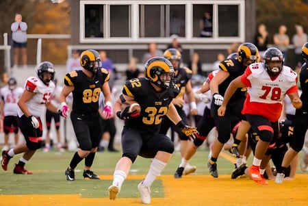 Eine Gruppe von Fußballspielern der Tilton School ist auf dem Sportfeld während eines intensiven Spiels zu sehen.