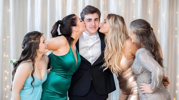 Eine Gruppe Schüler der Tilton School posiert bei einem formellen Event mit einem Jungen im Mittelpunkt.