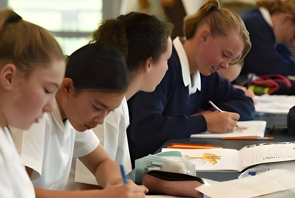 Schülerinnen der Timaru Girls School konzentrieren sich auf ihre Arbeit mit Büchern und Papieren im Unterricht.
