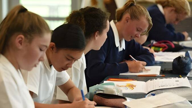 Schülerinnen der Timaru Girls School konzentrieren sich im Klassenzimmer auf ihre Lernmaterialien.