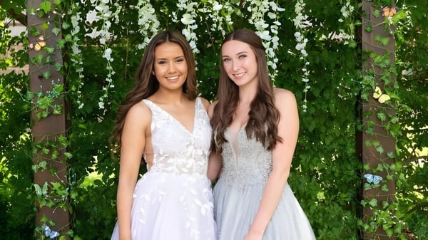 Zwei Schülerinnen der Timberline Secondary School stehen vor grünem Laub mit hängenden Ranken.