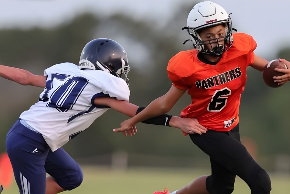 Zwei Fußballspieler in roten und blauen Trikots spielen auf dem Spielfeld der TMI Episcopal School.