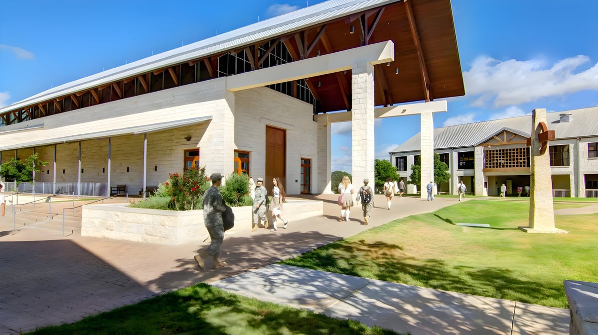 Das moderne Schulgebäude der TMI Episcopal School mit Holz- und Steinelementen in einer gepflegten Außenanlage.