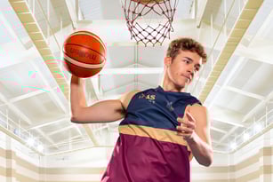 Ein Schüler der Toowoomba Anglican School hält einen Basketball in der hell beleuchteten Sporthalle.