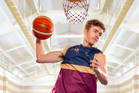 Ein Schüler der Toowoomba Anglican School hält einen Basketball vor dem Basketballkorb auf dem Spielfeld.