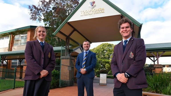 Drei Schüler in Schuluniform stehen vor dem Gebäude der Toowoomba Anglican School.
