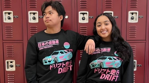 Zwei Schülerinnen und Schüler stehen vor roten Spinden auf dem Campus der Torrance High School.