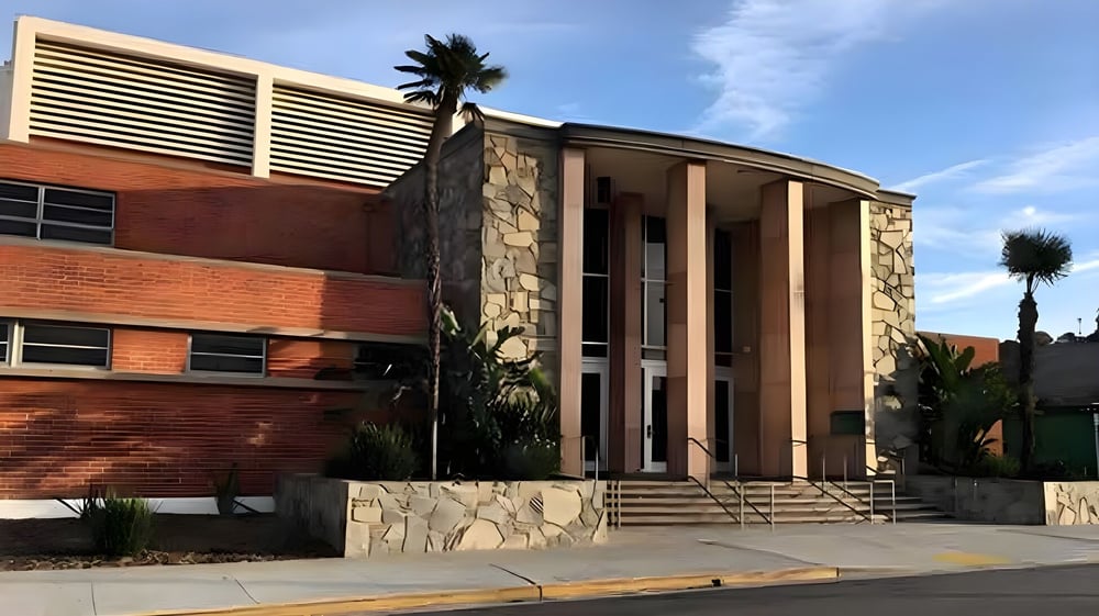 Das moderne mehrstöckige Gebäude mit Steinfassade und großen Fenstern steht auf dem Campus des Torrance Unified School District.