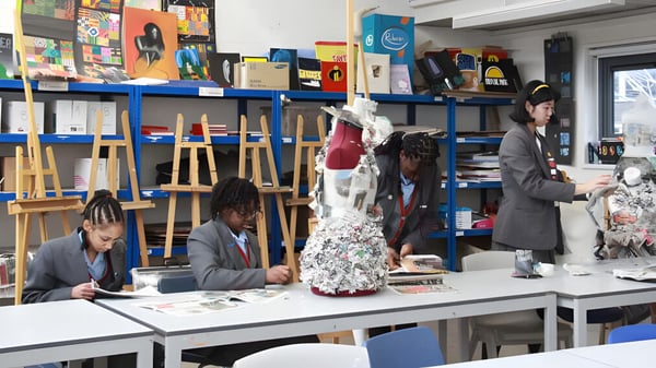 Schüler der Townley Grammar School arbeiten kreativ mit verschiedenen Kunstmaterialien im Klassenraum.