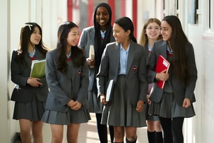 Schülerinnen und Schüler der Townley Grammar School gehen gemeinsam durch einen Flur mit roten Wänden.