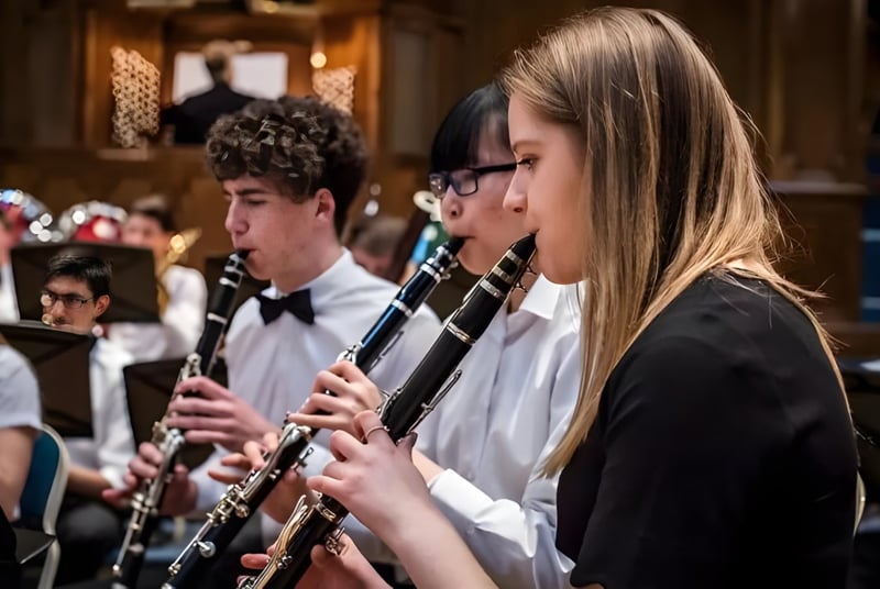Eine Gruppe junger Musiker spielt Windinstrumente im Konzertsaal des Trent College.