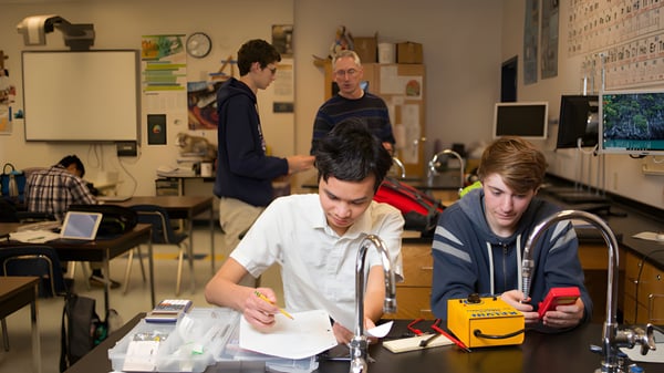 Eine Gruppe von Schülern sitzt in einem Klassenraum der Tri-Cities Prep Catholic High School und arbeitet gemeinsam.