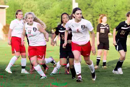 Eine Gruppe weiblicher Fußballspielerinnen läuft auf dem Sportplatz der Tri-State Christian School.