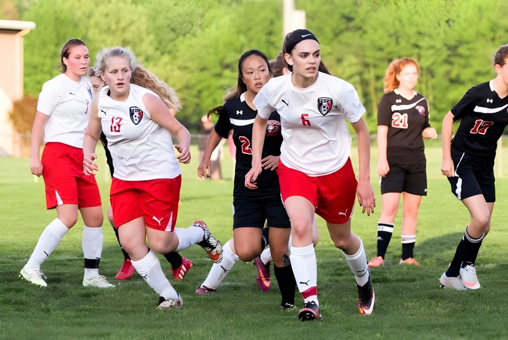 Eine Gruppe weiblicher Fußballspielerinnen läuft auf dem Sportplatz der Tri-State Christian School.