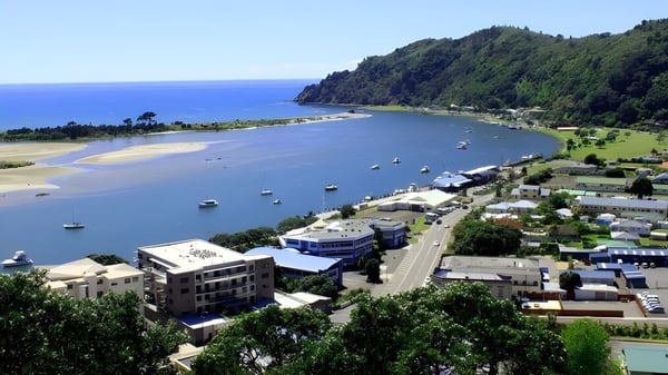 Ein malerischer Küstenort mit grünen Hügeln und ruhiger Bucht nahe der Trident High School.