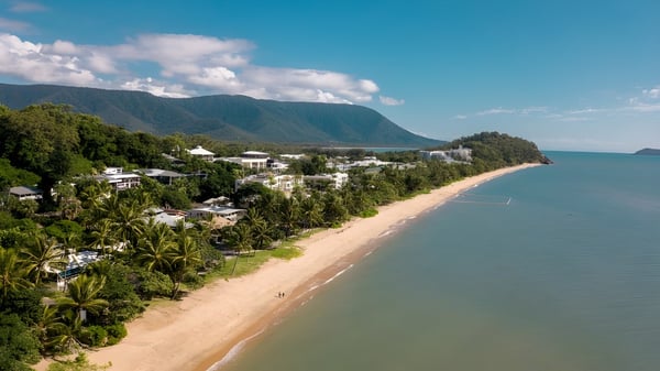 Eine malerische Küstenlandschaft nahe der Trinity Bay State High School mit grünen Hügeln und einem ruhigen Strand.