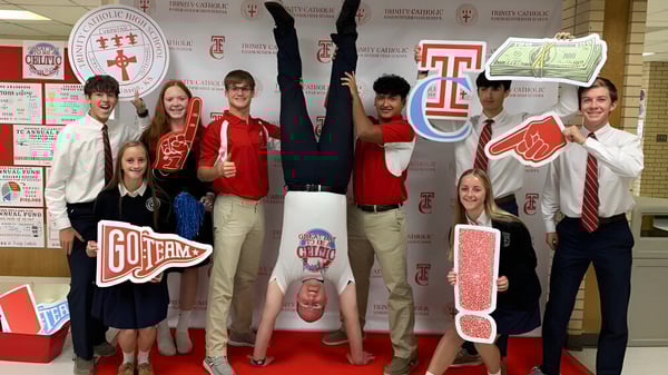 Eine Gruppe von Schülern posiert in roten und weißen Kleidern auf dem Campus der Trinity Catholic Jr/Sr High School.