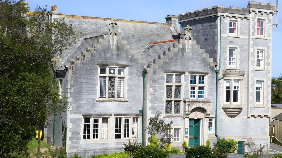 Das historische Stone Castle auf dem Gelände der Truro High School for Girls ist von grünen Pflanzen umgeben.